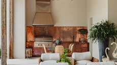 half outdoor kitchen with a copper backsplash and matching cabinets 
