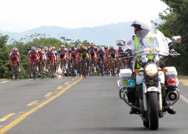 A police motorbike escorts the peloton on stage four