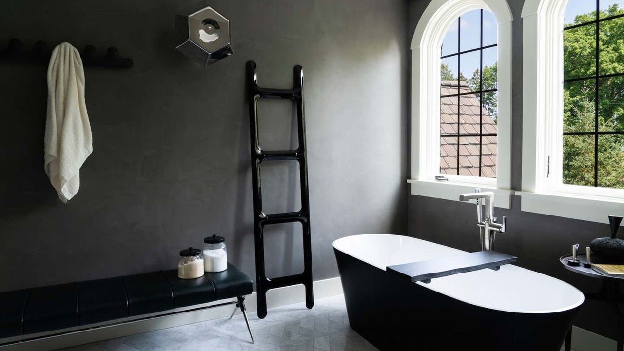 A black towel rail in a monochrome bathroom