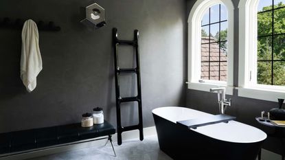 A black towel rail in a monochrome bathroom