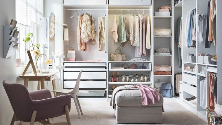 A walk-in closet area with clothes rails, drawers and shoe rack