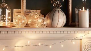 Fairy lights on a mantlepiece to create a sparkling Christmas party theme