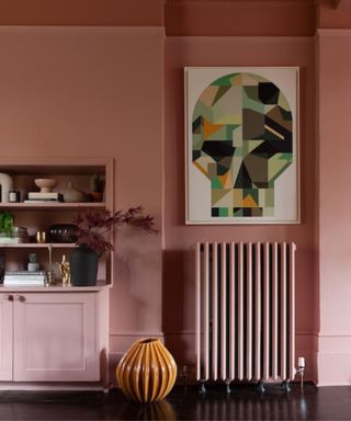 Color-filled pink room with traditional panel radiator and modern art print