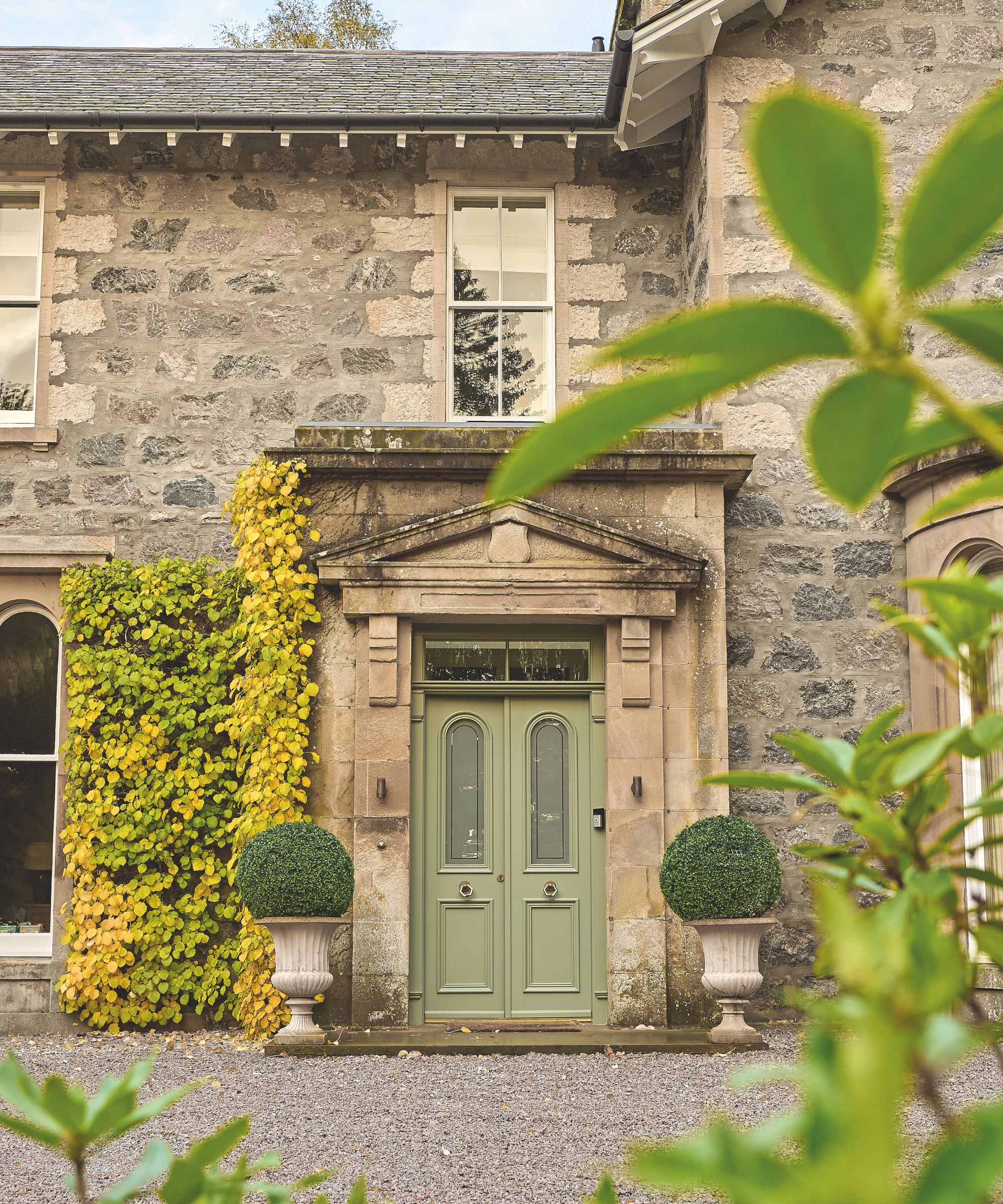 Exterior of stone house with pale green door
