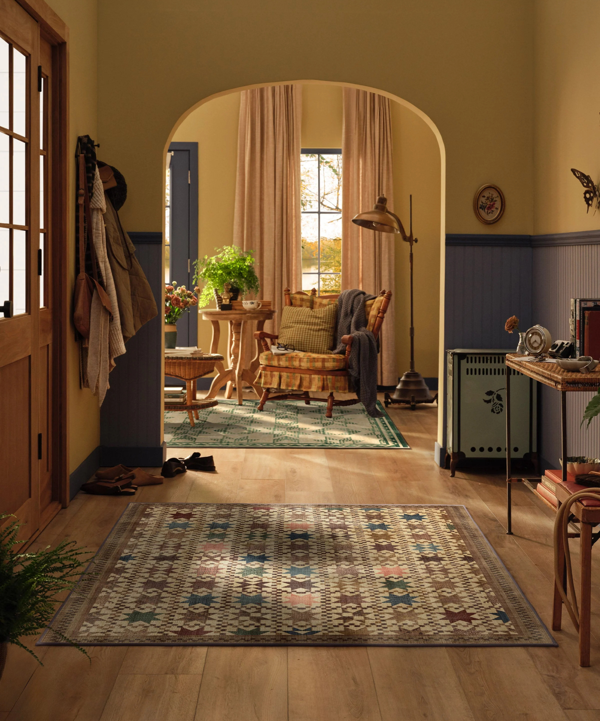 an entryway with a patchwork-style area rug on the floor