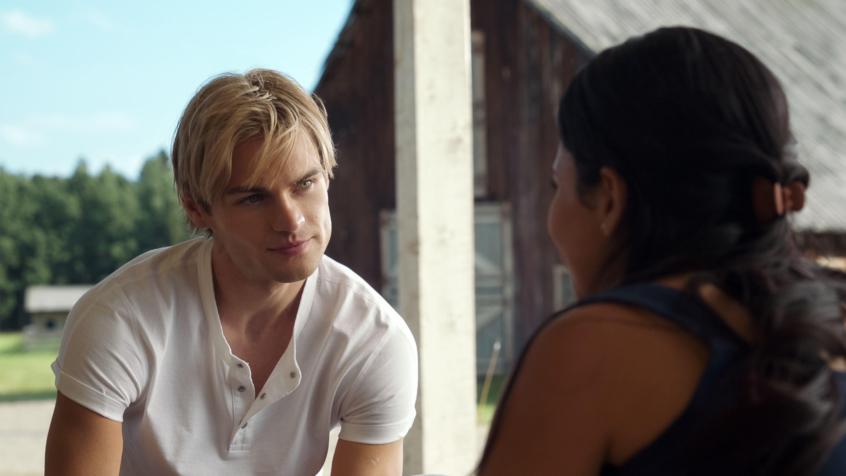 Cole smiles at Jackie as her back faces the camera.