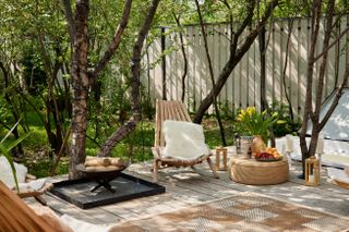 A shady backyard filled with bright plants and furniture