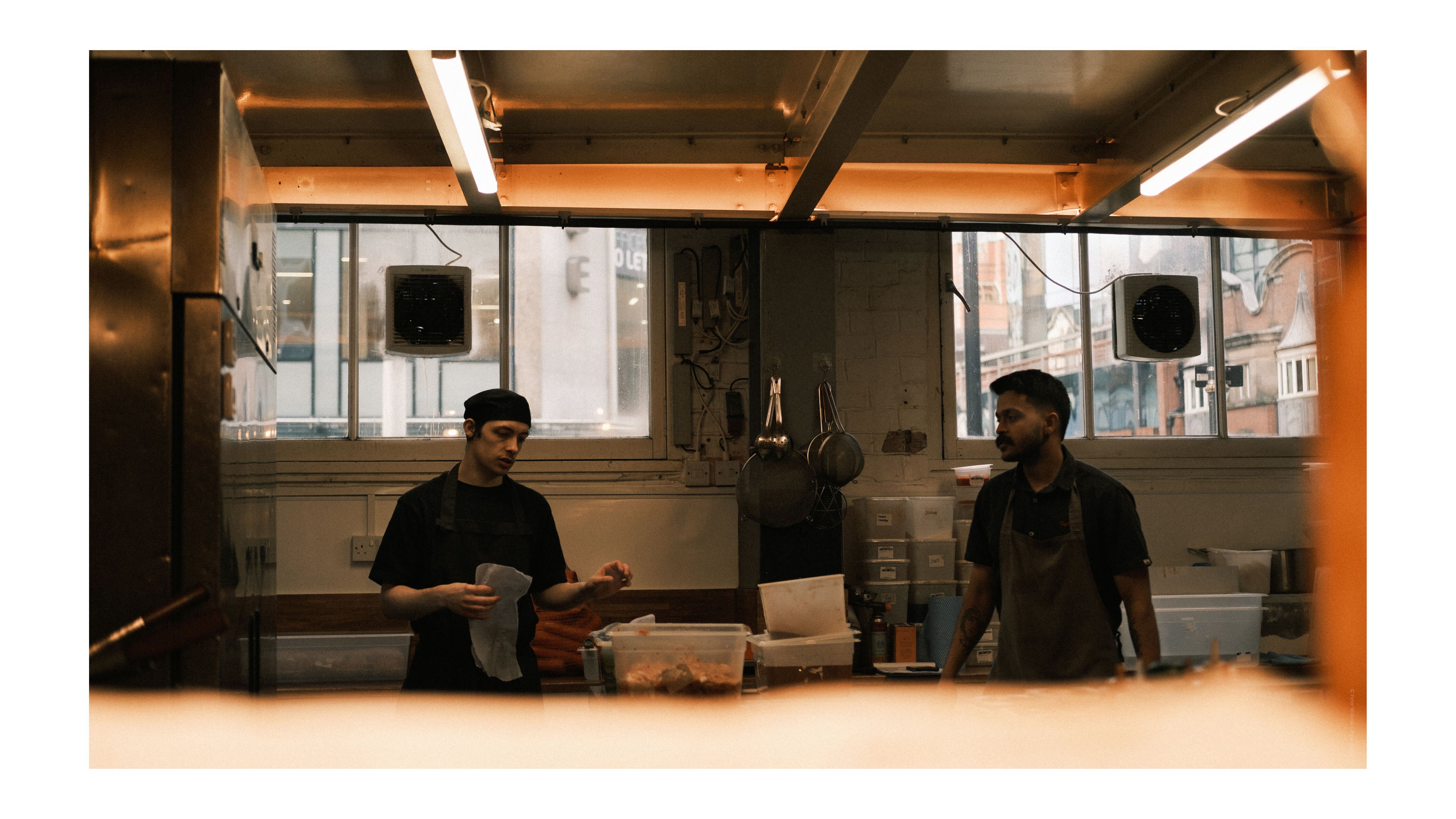 A photo of two chefs cooking in a restaurant