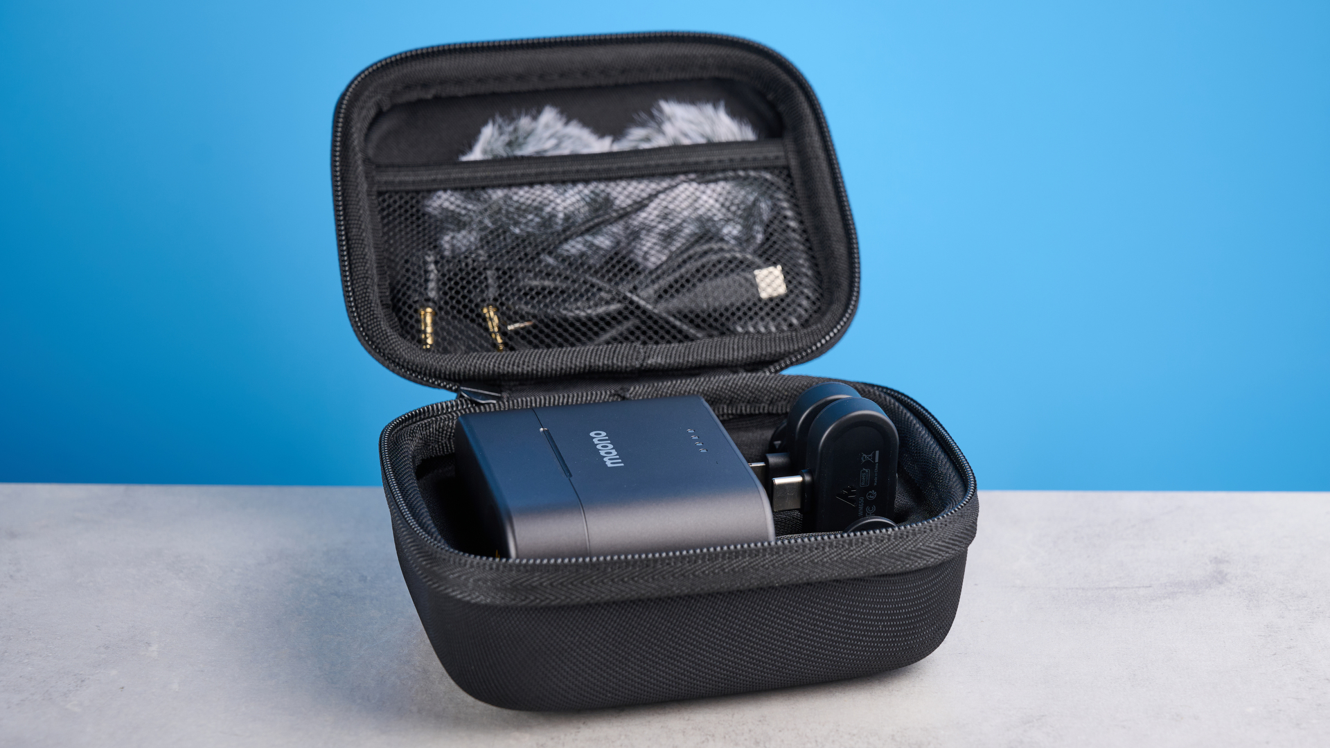 the maono wave t5 lavalier microphone shown against a blue background, showing the transmitters, receivers, and charging case