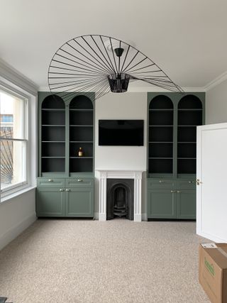 A living room with empty arched built-in alcove shelving