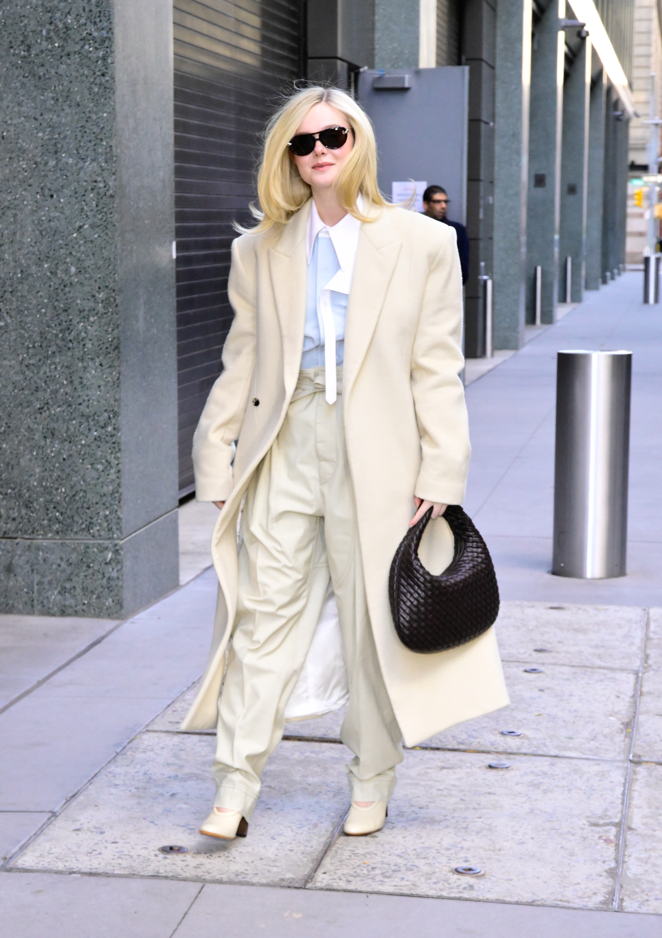 Elle Fanning with a flipped lob hairstyle, white suit, and black sunglasses on the street