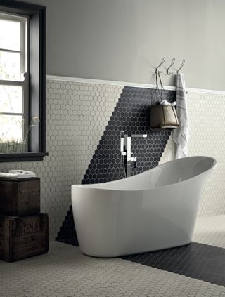 black and white bathroom with hexagon floor and wall tiles, white tub