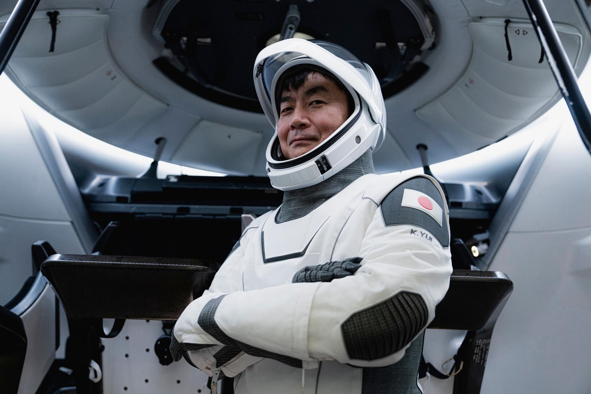 astronauts in white spacesuits pose for portraits