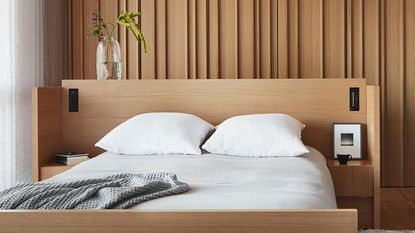 a bed with a wooden headboard and white bedding