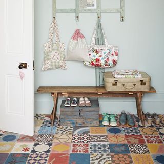 hallway with patterned tiles and wooden bench