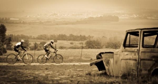 Kevin Evans and Adrien Niyonshuti pass by an old wreck