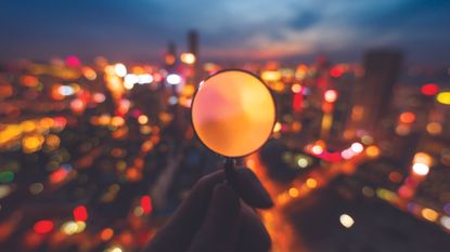 A magnifying glass examines a city