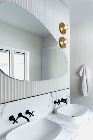 A bathroom with an organic shape mirror