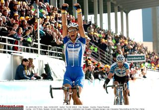 Boonen celebrates crossing the line in the Roubaix velodrome ahead of George Hincapie