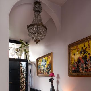 pink hallway with chandelier and painting on the wall