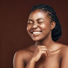 best toners - black model smiling with eyes shut and glowy skin