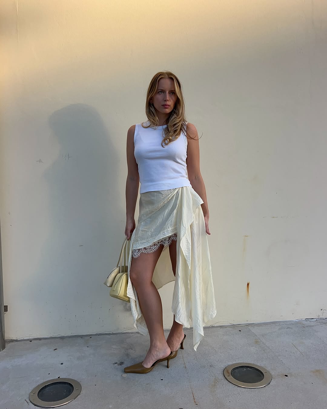 woman wearing asymmetrical skirt and white tank summer 2025