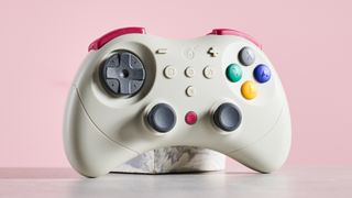 GuliKit Elves 2 Pro leaning on plinth on desk with pink background