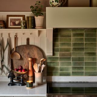 Green kitchen backsplash and kitchenalia styled on countertop