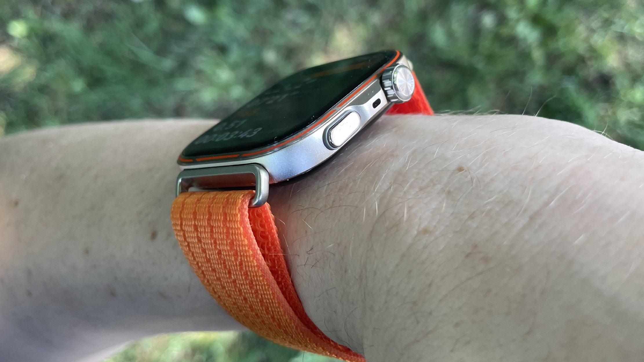 Huawei Watch Fit 5 Pro worn on a run, in front of a grassy background
