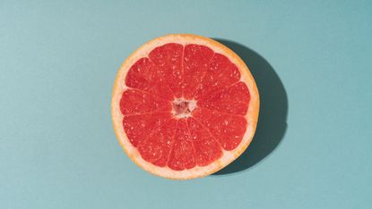 half of grapefruit on blue background 