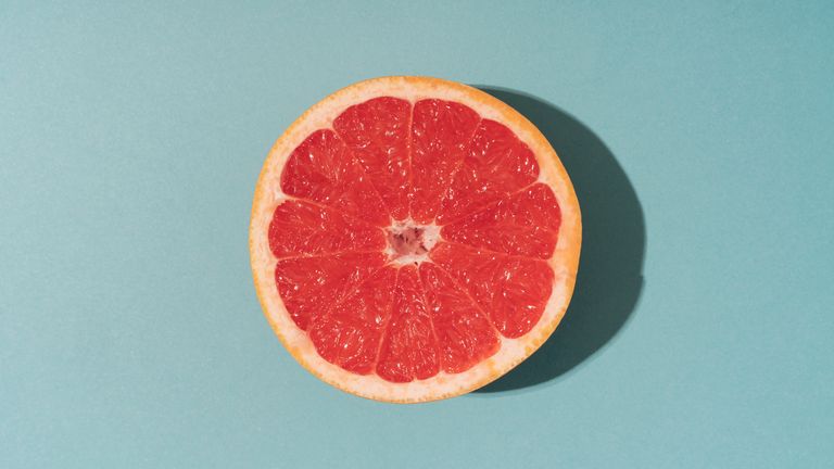 half of grapefruit on blue background