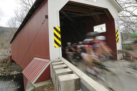 The peloton flies through the Eagleville covered bridge