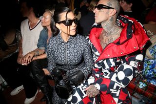 Kourtney Kardashian Barker and Travis Barker sit front row at a fashion show