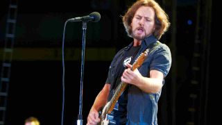 Pearl Jam’s Eddie Vedder playing guitar onstage in 2012