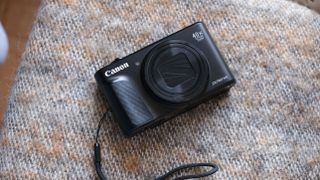 Canon PowerShot SX740 HS compact camera on a brown wool blanket