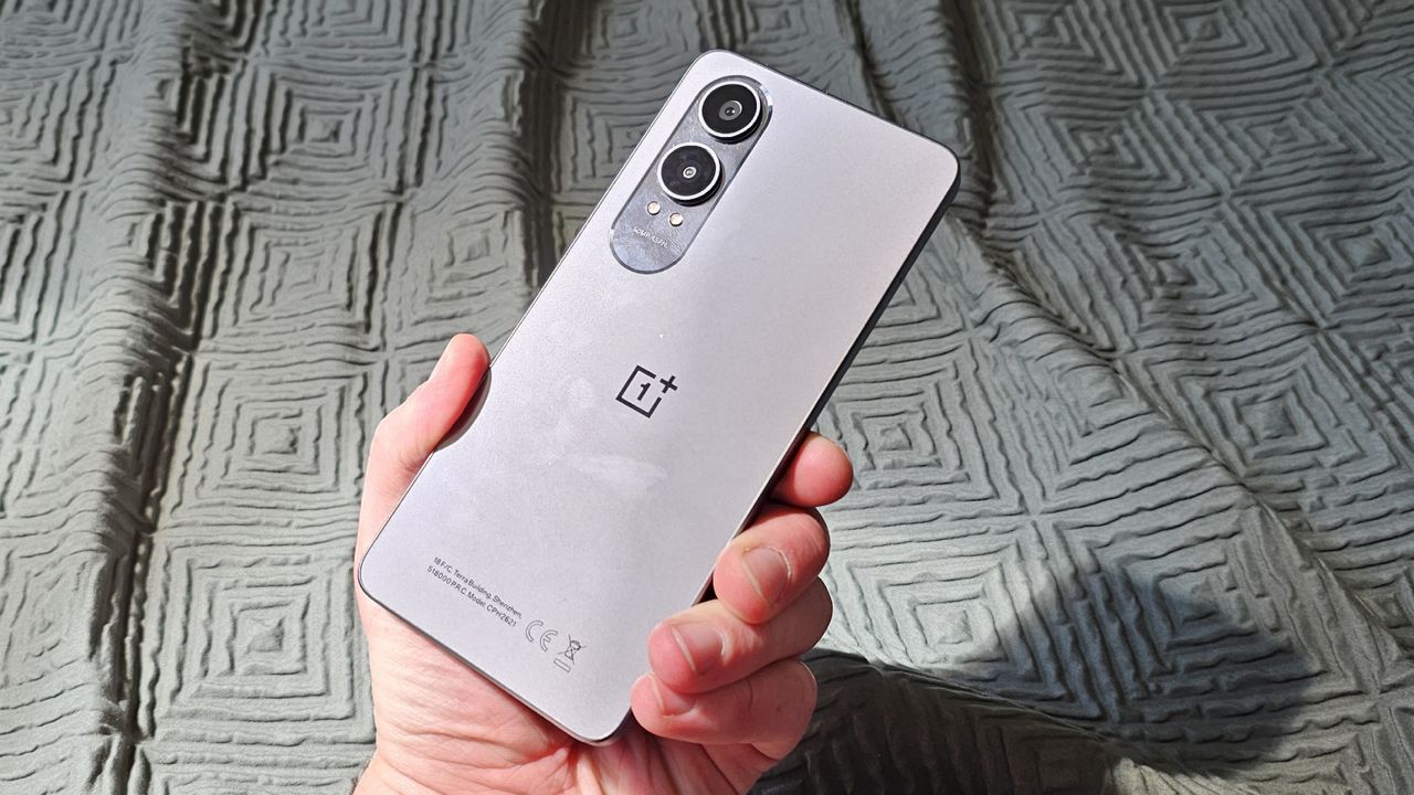 The OnePlus Nord CE 4 Lite against a green curtain.