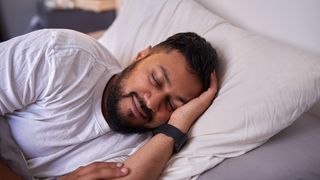 how fitness trackers monitor your sleep: Image shows man sleeping