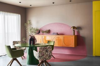 A bright pink wall balanced against an orange cabinet