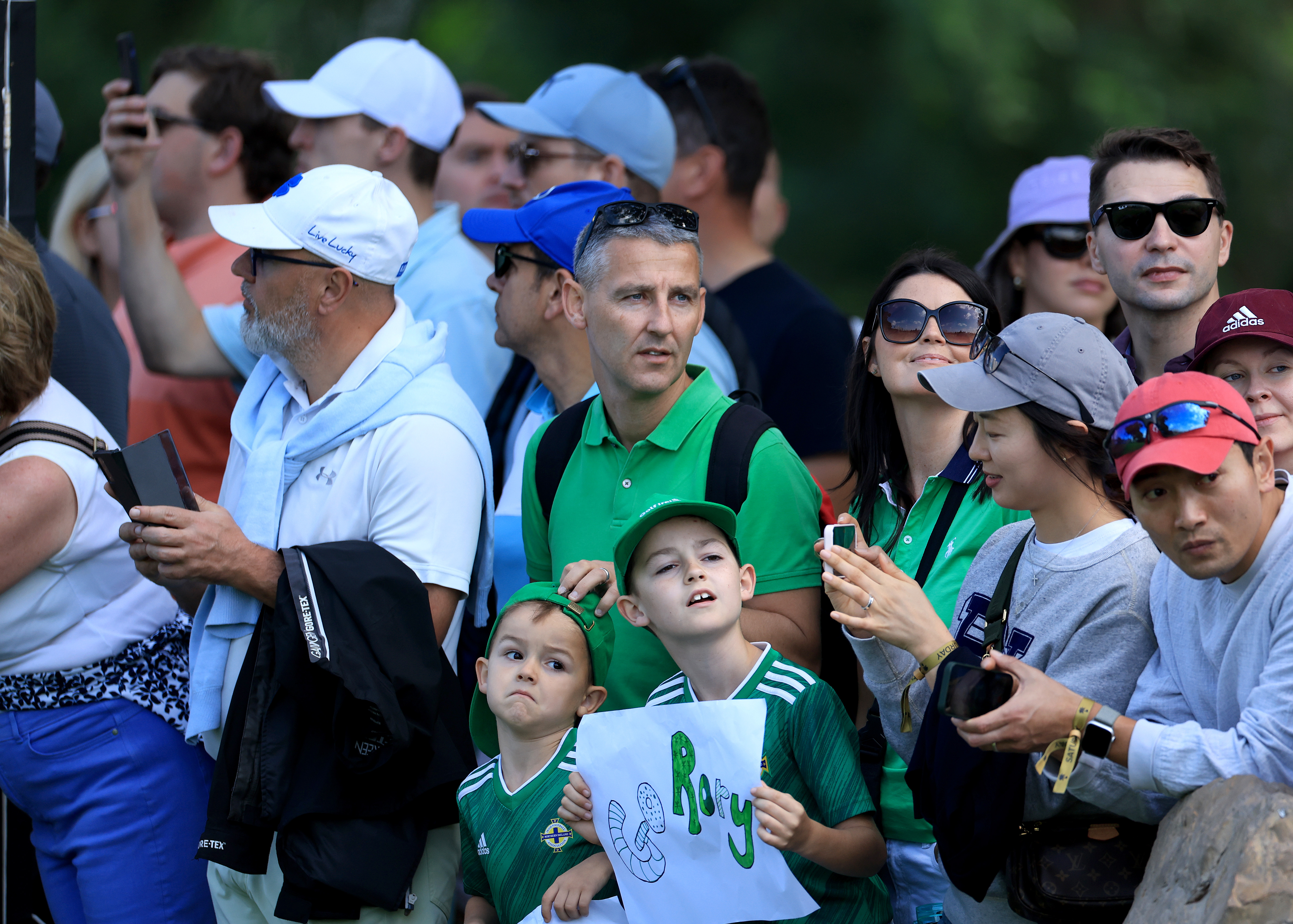 Young children and Rory McIlroy fans watching the golf