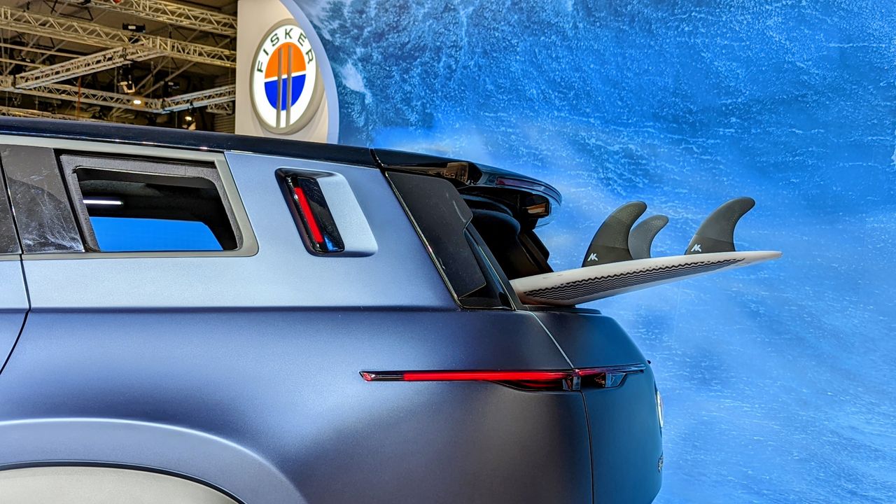 Rear windscreen rolled down with a surf board poking out of it