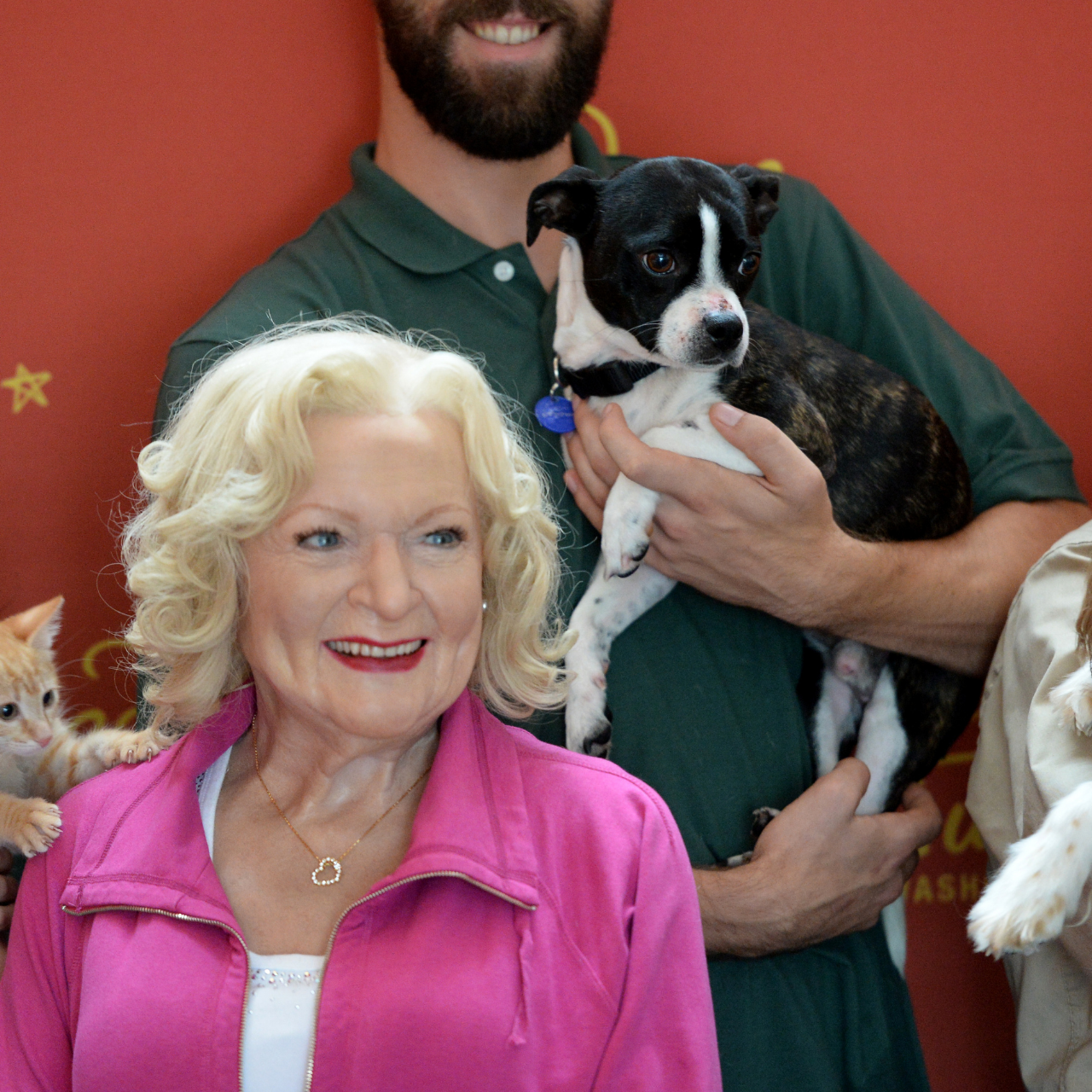 Betty White's wax Madame Tussaud's figure poses with along with many adoptable dogs, cats, puppies and kittens