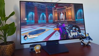 LG UltraGear 32GS95UE-B with Overwatch 2 gameplay on screen and first-person Pharah