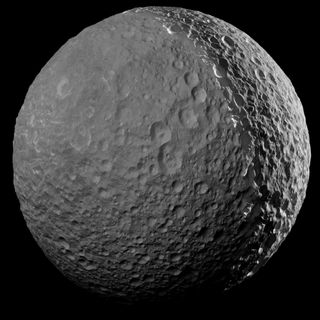 Saturn's moon Mimas as imaged by the Cassini spacecraft during its final flyby in January. The left side, lit only by reflected light, has been enhanced to better show the moon's features. The image depicts about 820 feet (250 meters) per pixel.