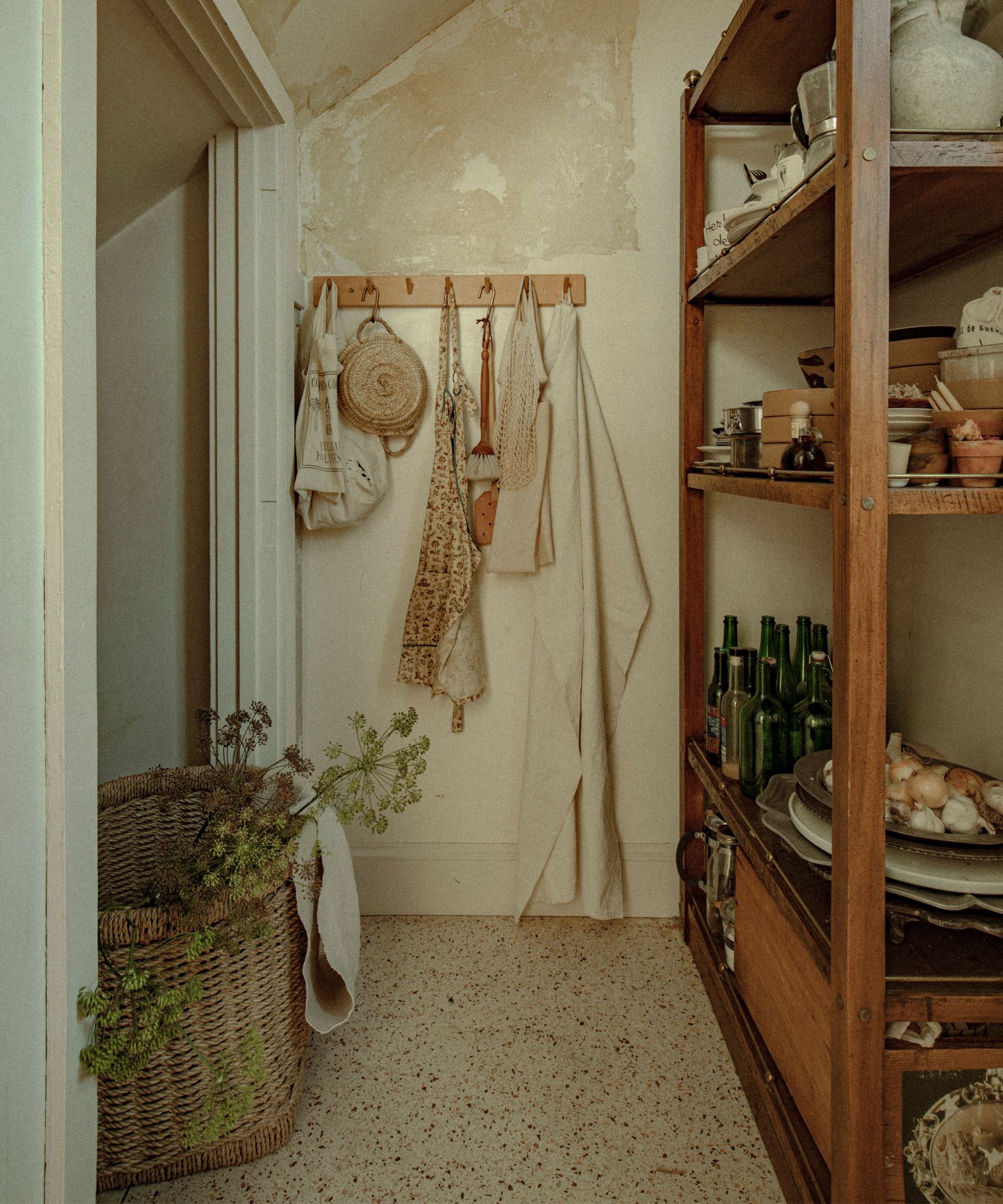 a vintage plaster peeling larder with terrazzo floors and wooden shelving