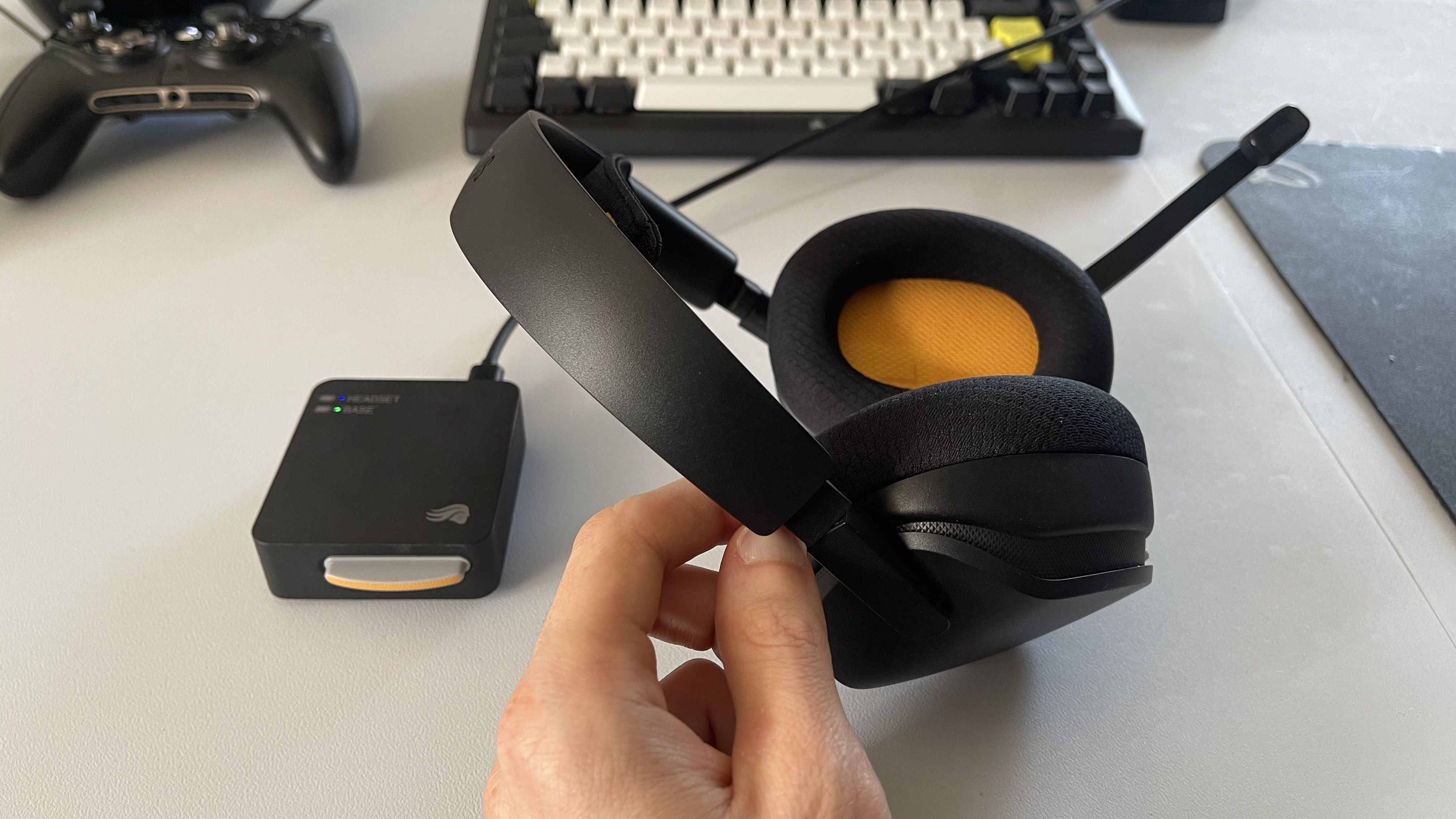 The Glorious GHS Wireless InfinitePlay gaming headset in black and orange on a plain white desktop.