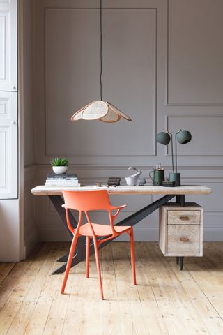 home office with wall panelling, wooden floor, orange modern chair, wood and metal desk, pendant light, desk lamp