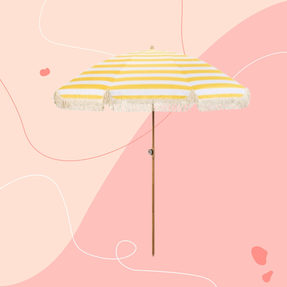 Livarno Home parasol in butter yellow on a pink background.