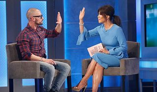 Julie Chen high fives an evicted house guest on Big Brother