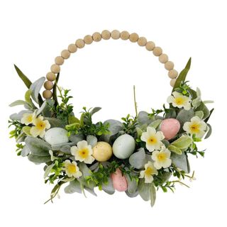 A light wooden beaded wreath with green leaves, light green, blue, and pink eggs and yellow flowers decorating the bottom of it