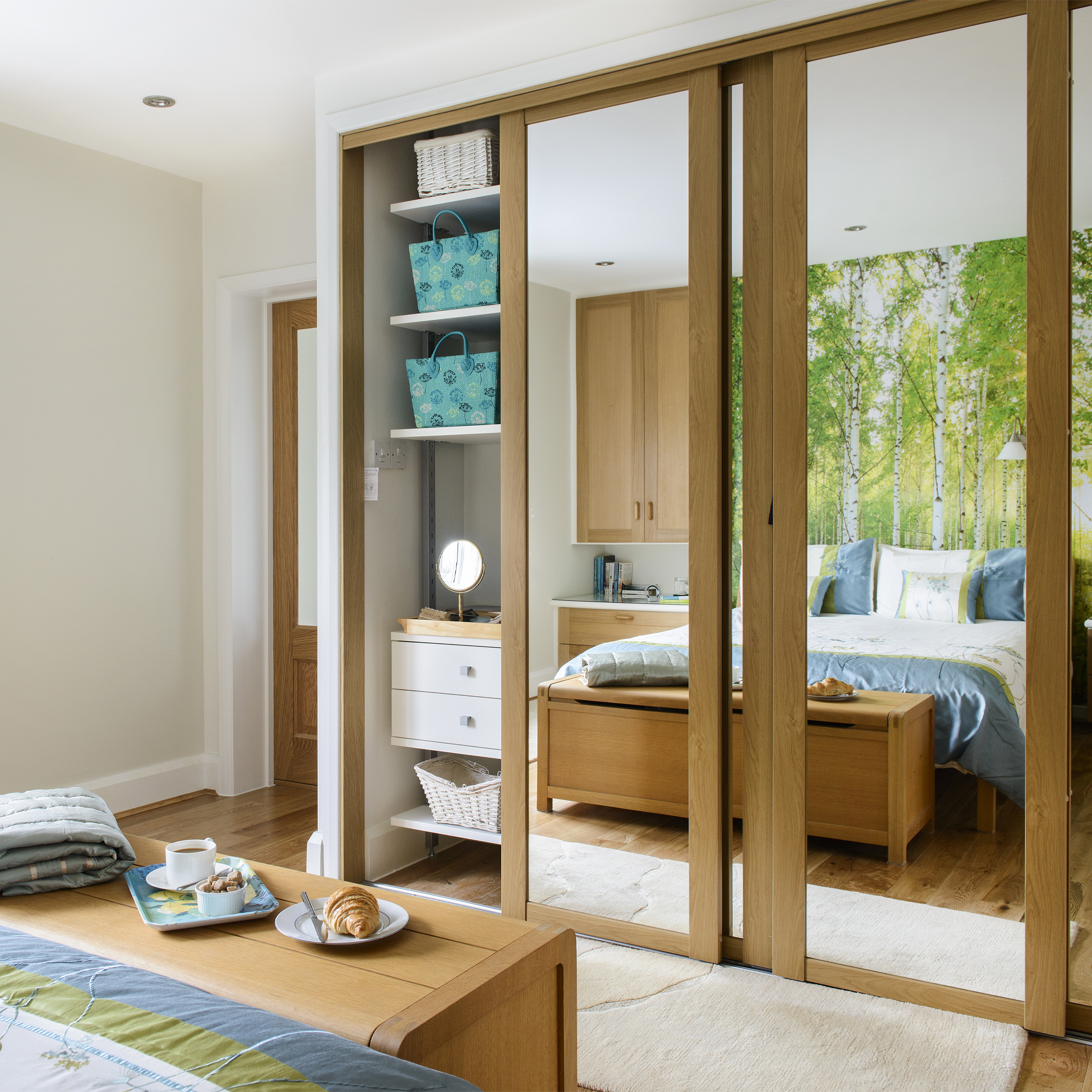 A bedroom with a mirrored wardrobe
